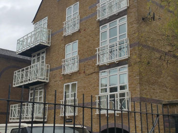 A brick building with large windows and balcony accents