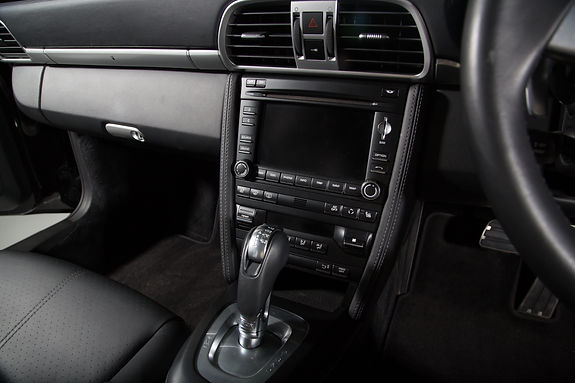 Car interior with black leather seats, a sleek dashboard, and a central touchscreen