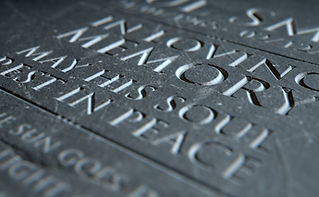 A 3D render of closeup of a carved and etched tombstone highlighting the word in loving me