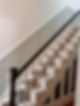 A staircase featuring white wooden railings and steps beside a floral wallpapered wall