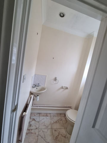 A bathroom with white painted walls and a sink
