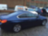 A blue car outside a building after window tinting