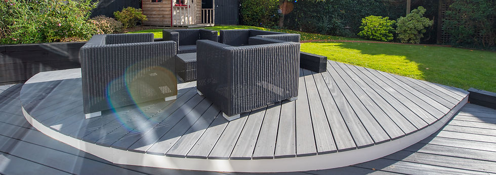 Outdoor patio with grey wooden decking features a set of black wicker chairs arranged circularly