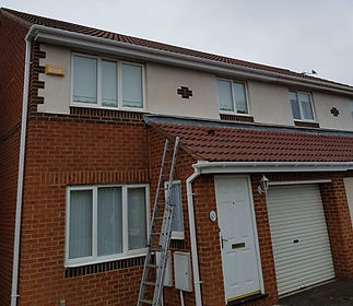 A two-story brick house with white trim, a tiled roof, and a garage