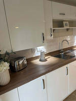 Kitchen with a wooden countertop and white cabinets