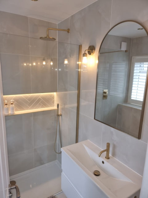 A sink, mirror and shower with a lamp