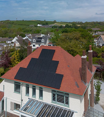 Modern house with a red tiled roof featuring a black solar panel array