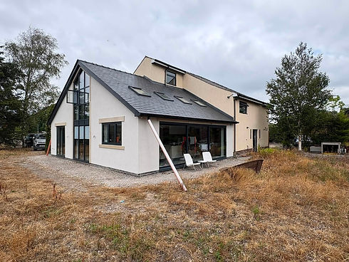 Modern white rendered house with large windows and lawn