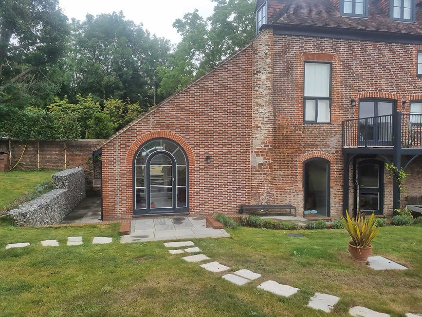 A modern red-bricked house with a garden