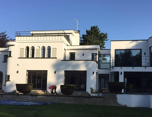 White rendered modern house exterior with glass balcony