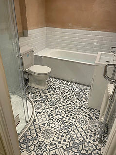 Modern bathroom layout featuring a white bath toilet and patterned floor tiles
