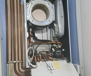 Internal electrical wiring and pipework inside an open gas boiler unit