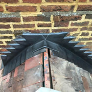 Close-up of a roof's edge showing a lead work and brick wall