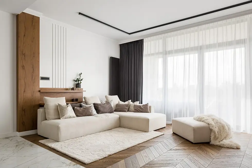 Modern living room with cream sectional sofa, decorative pillows, and sheer curtains