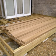 A stack of wooden planks on a partially constructed deck
