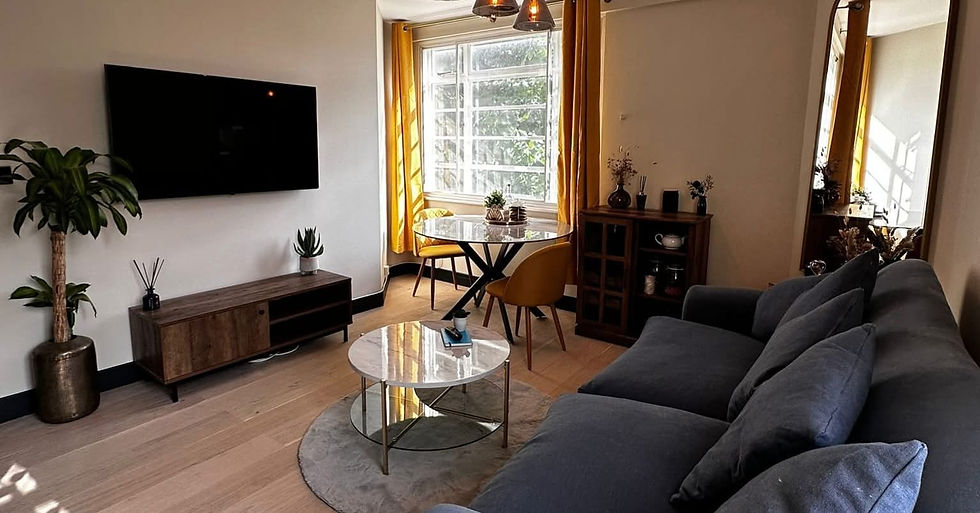 A cosy living room featuring a grey sofa, marble coffee table, and yellow curtains
