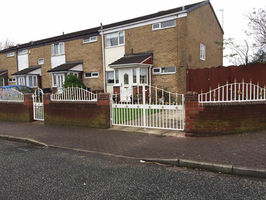 A house with white steel gate and railings