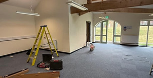 Spacious interior of a restored historic building with exposed wooden roof beams