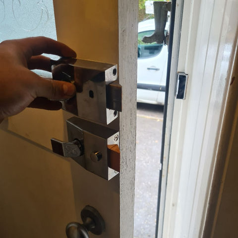 A person fixing a door lock
