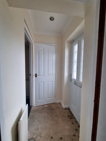 A hallway with white doors and a radiator