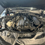 Car engine with the hood open, displaying various mechanical components