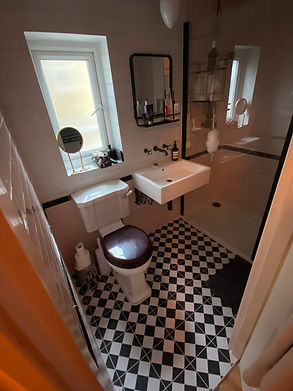 A bathroom with black and white checkered floor and a glass shower