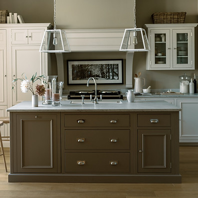 Modern kitchen with a central brown island, marble countertop, and wooden stool