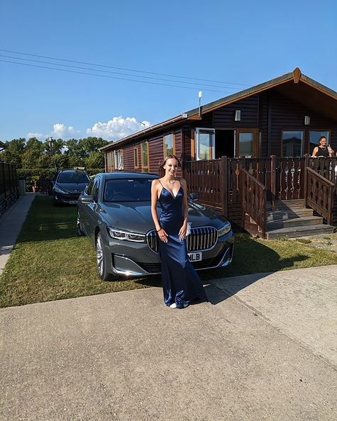 picture of a lady ready for prom in front of a luxury car