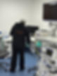 A person in a black sweatshirt is cleaning a medical office with a mop