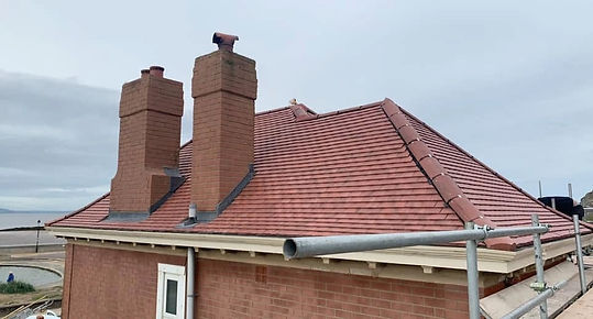 Brick chimneys featuring twin pots built on a tiled domestic roof
