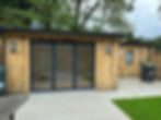 Newly installed wooden shed with a black glass door