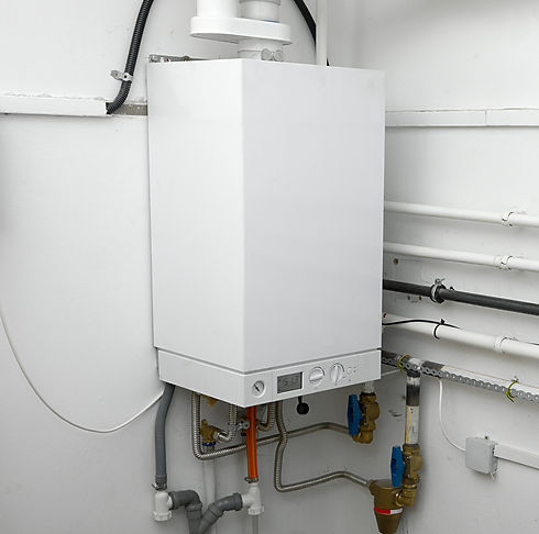 Sleek white modern combi boiler mounted on a clean wall with visible underlying pipe connections
