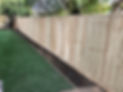 A back garden showcasing a wooden fence with artificial grass