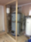 A partially finished utility room featuring a hot water tank