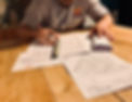 A man is reviewing some documents on a wooden table