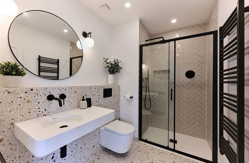 A bathroom with a glass shower area and a round mirror