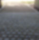 A cobblestone path leads to a gravel driveway