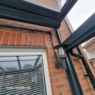 Brick home extension showing dark roof soffit with integrated down light fixtures