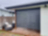 Grey slatted patio screen Nudgee on a ground level wooden deck. 