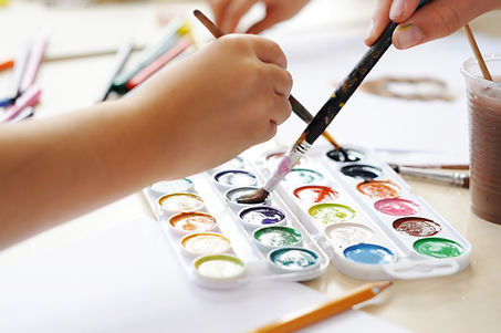 Children use watercolour paints to create images on paper