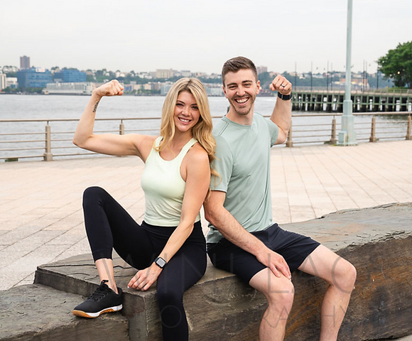 Kat and Andrew flexing on a bench.
