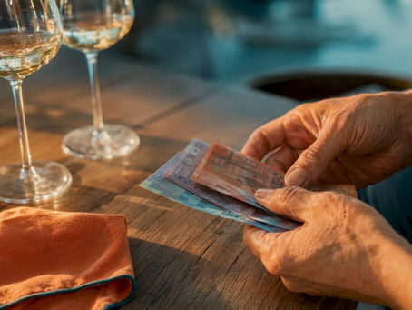 Cash notes beside wine glasses