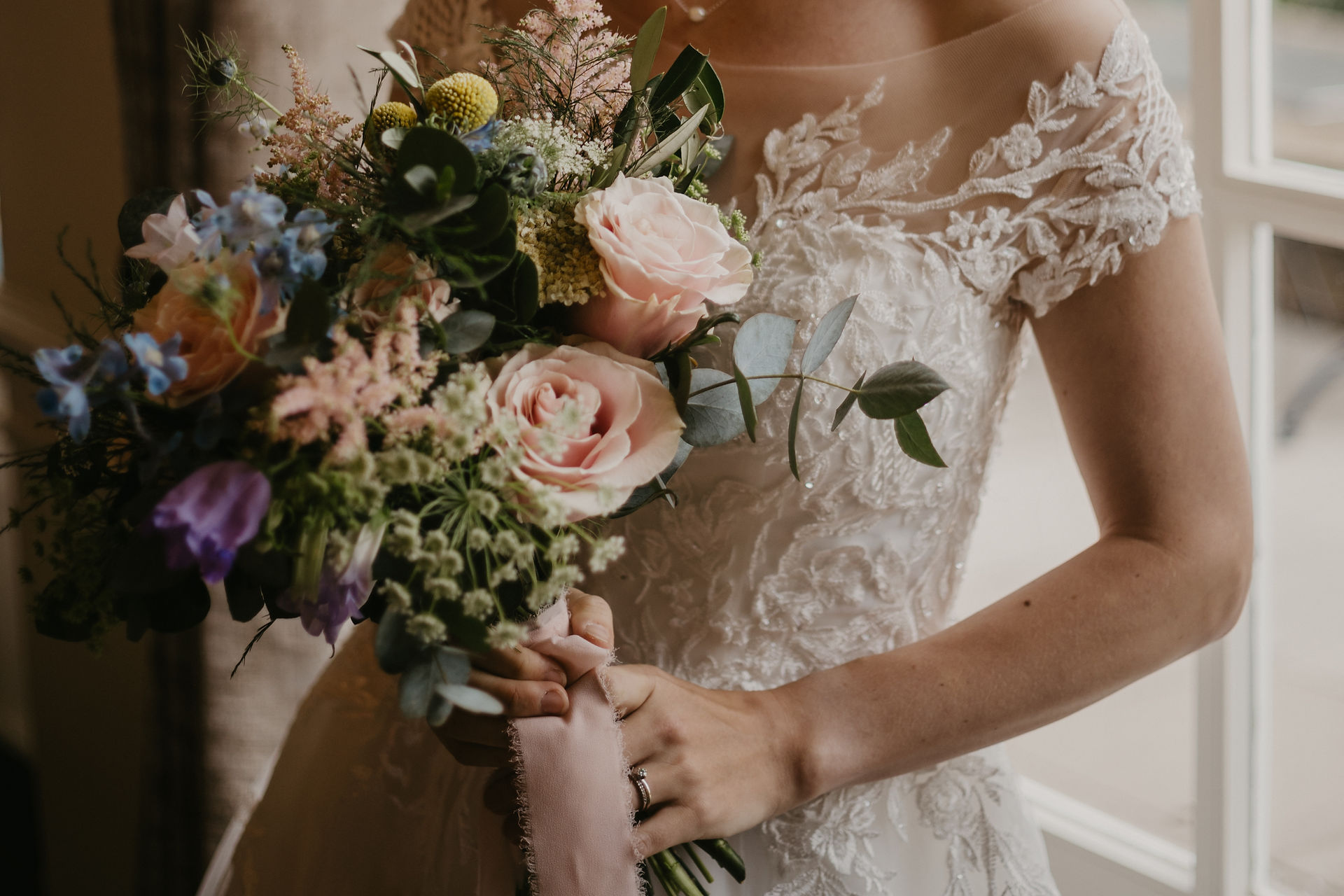 Bride holding a pastel wedding bouquet 