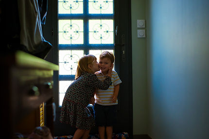 Séance photo famille à domicile à Nantes – enfants dans la lumière naturelle d'une fenêtre