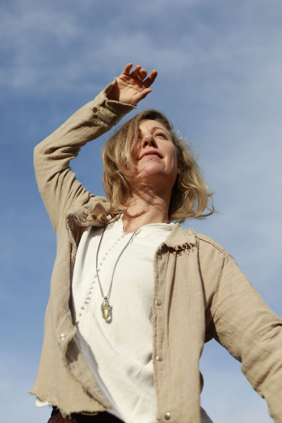 Nieke Franken with arms raised joyfully outdoors, embodying freedom and connection to nature