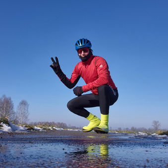Cyclist in the winter sunshine with snow in the background
