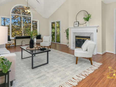 Bright living room with white chairs, fireplace, arched window and wood floors; EPIC logo in bottom right.