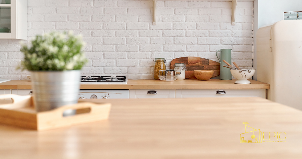 Modern kitchen with white brick wall, wooden counters, and assorted jars. A potted plant sits in the foreground. Bright and tidy.
