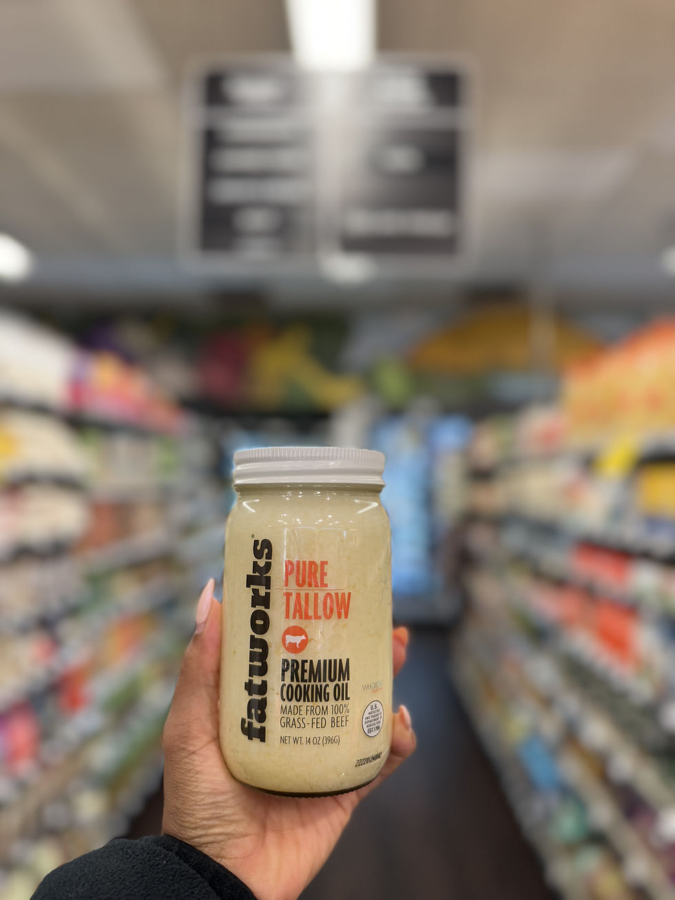 A person holding Fatworks Grass-Fed Beef Tallow at Rosewood Market.