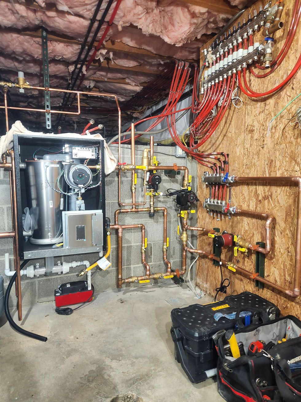 Boiler room with copper piping and red PEX manifolds in a Colorado home